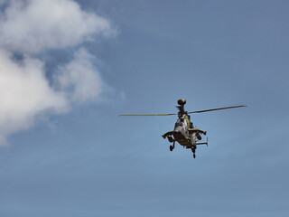 In the distance a green military helicopter is approaching.