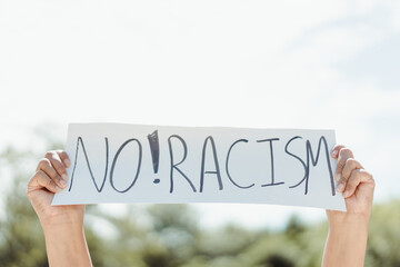 No rasicm End rasicm.Crowd of protesters people on street.black woman raised hands showing sig board revolution protest.Black Lives Matter.Justice in USA.