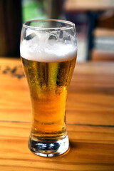 refreshing glass of draft beer isolated on wooden table