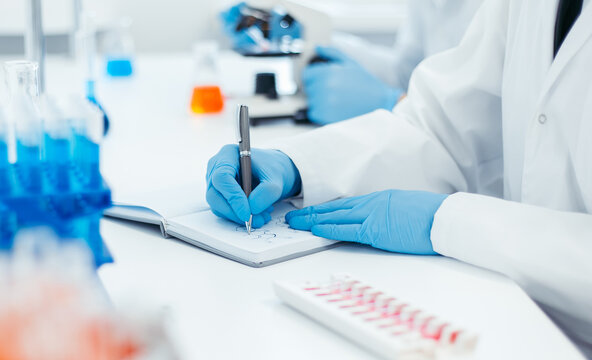 Close Up. Scientist Recording The Results Of The Study In A Laboratory Journal.