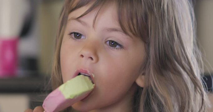 Adorable little girl licking ice cream