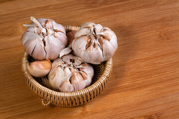 garlic bulb in wooden bowl place on background Concept of healthy food