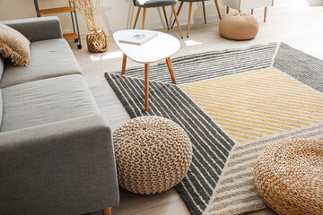 Stylish interior of living room with carpet and sofa