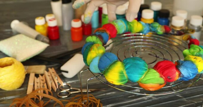 Woman applying tie dye technique to t shirt