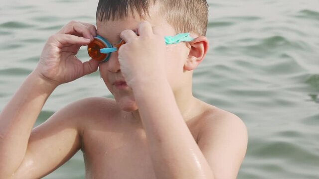 Close up slow motion, of caucasian toddler boy wearing sea googles, at sea of Marathonas, Greece