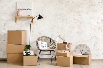 Cardboard boxes with belongings and armchair in new flat on moving day