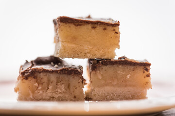 three yummy sweet treats.  caramel , and cookie crust with chocolate frosting dessert with white background