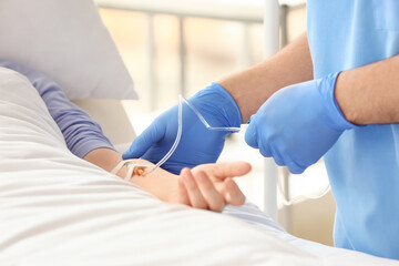 Female doctor working with patient in hospital room, closeup