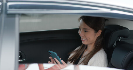 Obraz na płótnie Canvas Woman use mobile phone and sits inside car