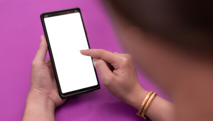 a woman Hand holding black mobile phone with blank white screen purple background.