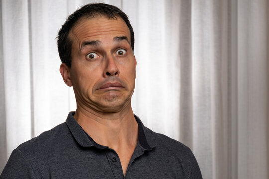 Mature man (44 years old) pulling a funny face of surprise with wide eyes.
