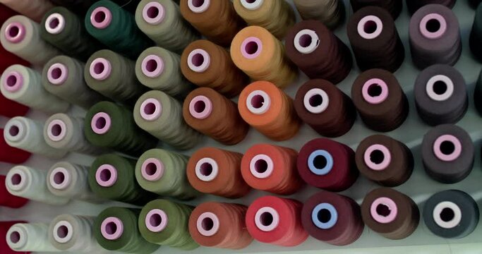 Background of colorful rolls of woolen thread hang on a wall