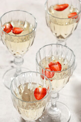 Glasses of tasty champagne with strawberry on table