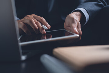 Businessman using digital tablet working on laptop computer surfing the internet