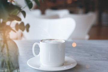 Cup of coffee and digital tablet on table in coffee shop