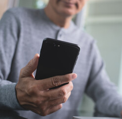 Casual man using mobile smart phone connecting internet at home 