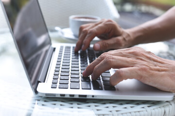 Man typing on laptop computer online working and surfing internet