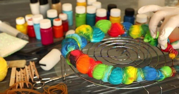 Woman applying tie dye technique to t shirt