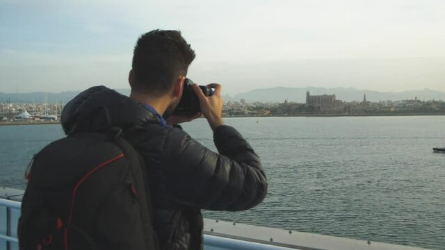 Traveler with camera backpack takes a picture from a cruise ship of the stunning Catherdral in Palma de Mallorca, Spain. 180FPS Slowmotion Footage.