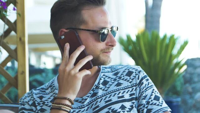 Slowmotion footage of a young man having a phone call with his smart phone / iPhone8