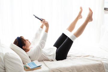 タブレットで動画を見ながらストレッチをする女性