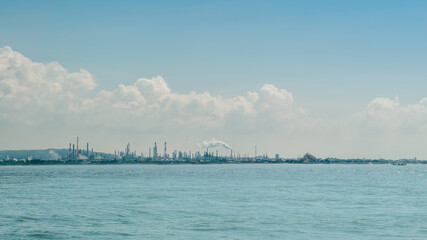 Industrial landscape view from the ocean. Sea pollution and ecological problem