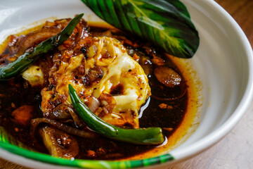 Fried eggs cooked in spicy soy sauce.