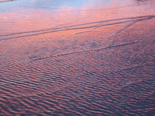 Abstract landscape reflection of a pink sunset on waves