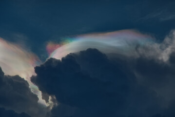 Colorful iridescent cloud over rain cloud in a evening