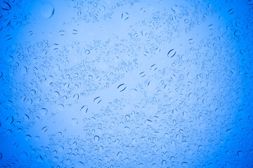 Rain droplets on blue glass background, Water drops on blue glass.