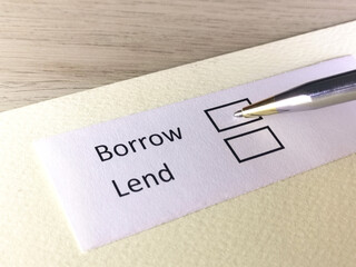 One person is answering question on a piece of paper. The person is thinking to borrow or to lend.