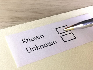 One person is answering question on a piece of paper. The person is thinking to be known or unknown.