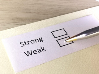 One person is answering question on a piece of paper. The person is thinking to be strong or weak.
