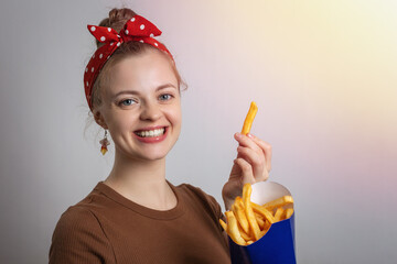 Smiling young Caucasian woman girl holding eating big size french fries portion