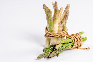 Green and white fresh asparagus on a white background