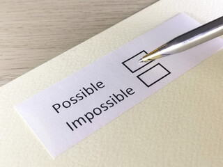 One person is answering question on a piece of paper. The person is thinking to be possible or impossible.