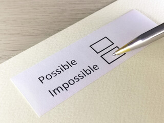 One person is answering question on a piece of paper. The person is thinking to be possible or impossible.