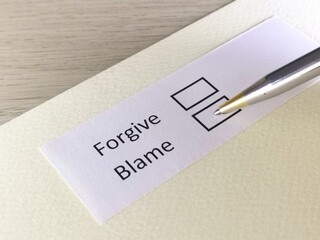 One person is answering question on a piece of paper. The person is thinking to forgive or to blame.