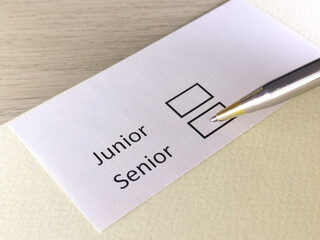 One person is answering question on a piece of paper. The person is thinking to be junior or senior.