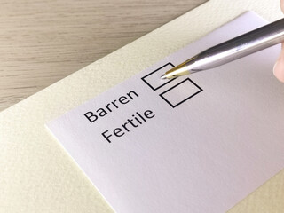 One person is answering question on a piece of paper. The person is thinking to be barren or...