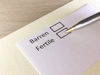 One person is answering question on a piece of paper. The person is thinking to be barren or...