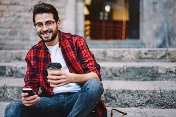 Happy male tourist satisfied with good connection in roaming talking with friend about vacations