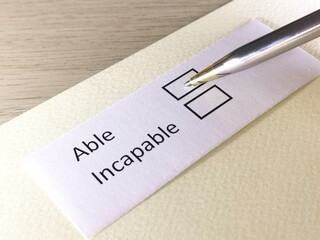 One person is answering question on a piece of paper. The person is thinking to be able or incapable.