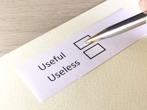 One person is answering question on a piece of paper. The person is thinking to be useless or useful.