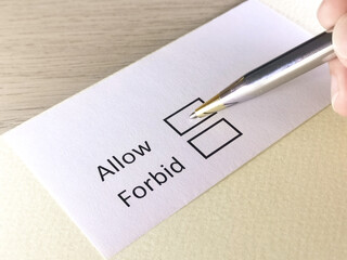 One person is answering question on a piece of paper. The person is thinking to allow or to forbid.