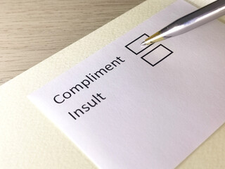 One person is answering question on a piece of paper. The person is thinking to give compliment or...