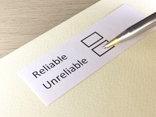 One person is answering question on a piece of paper. The person is thinking to be reliable or unreliable.