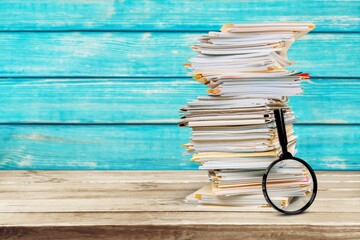 File folders with documents and magnifying glass on the desk