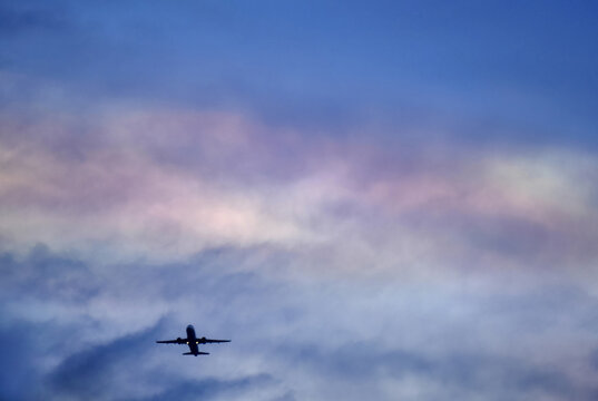 cloud iridescence during sunset with airplane / rainblow color of sky for envronment, travel and space design background