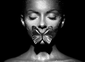 Fashion model woman in bright sparkles and lights posing in studio. Portrait of beautiful sexy...